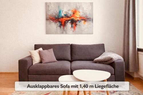 ein Wohnzimmer mit einer Couch und einem Gemälde in der Unterkunft Comfycation Gera in Gera