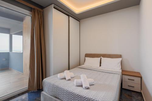 ein Schlafzimmer mit einem Bett, auf dem zwei Handtücher liegen in der Unterkunft Poseidon Girni Sea View Apartments in Paralia Katerinis