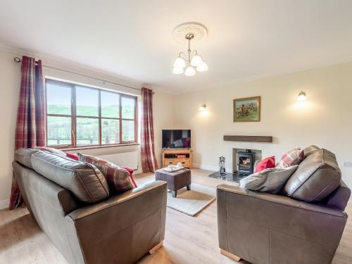 a living room with two couches and a fireplace at Melancroft in Llanfihangel-nant-Melan