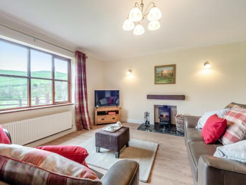 a living room with a couch and a tv at Melancroft in Llanfihangel-nant-Melan