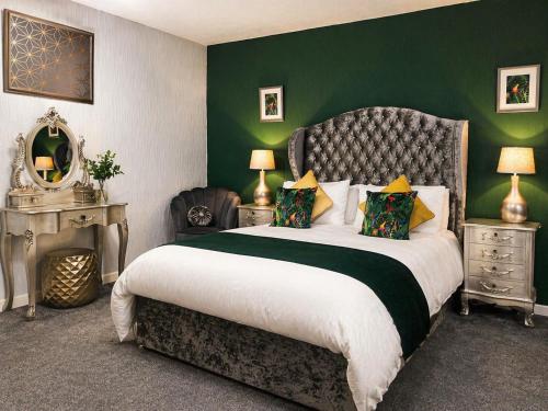 a bedroom with a large bed with a green wall at Saphire Apartments Spacious 1 Bed Apartment Sleeps 6 with Free Parking and Garden in Giffnock
