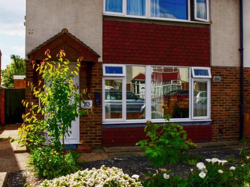 a red brick house with a car in the window at St Mary's Crescent House in Stanwell