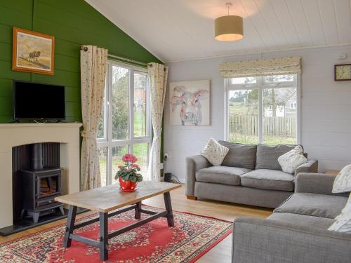a living room with a couch and a table at Buckland Lodge in Pentridge