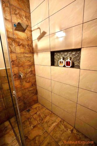 a bathroom with a shower with two clocks in it at Boana Explora Pachijal in Pedro Vicente Maldonado