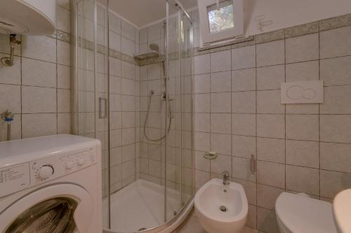 a bathroom with a washing machine and a shower at Il Boschetto sul Mare - Goelba in Capoliveri
