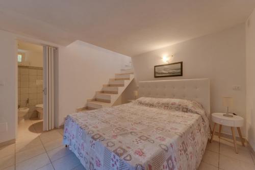 a small bedroom with a bed and a staircase at Il Boschetto sul Mare - Goelba in Capoliveri