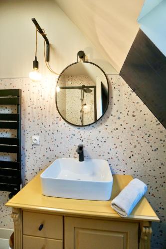 a bathroom with a sink and a mirror at La Parenthèse -piscine in Ploemeur