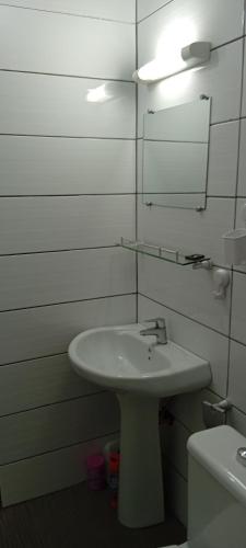 a bathroom with a sink and a mirror and a toilet at Johannys'co in Abidjan