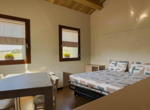a bedroom with a bed and a desk and window at casale dei cinque colli APPARTAMENTO in Ostra