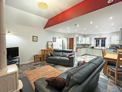 a living room with two couches and a kitchen at Gelli Hir in Bronant