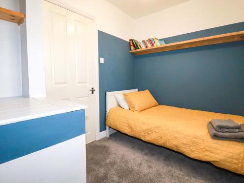 a bedroom with a bed and a blue wall at Trelowen in Wadebridge