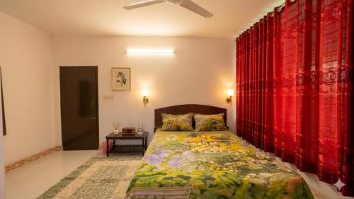 a bedroom with a bed with red curtains at Hotel Priyatama Residential in Dhaka