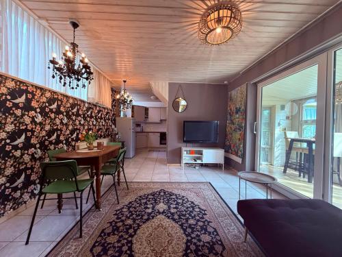 a living room with a table and chairs and a television at Indigena Forest Retreat -Entire 6 persons Family home near Efteling and Dunes in Sprang-Capelle