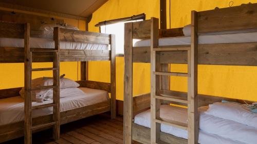 two bunk beds in a room with a yellow wall at The Camp at The Wave in Bristol