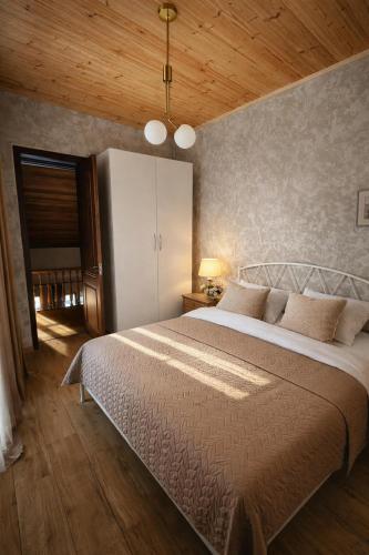 a bedroom with a large bed and a wooden ceiling at Gudaleti Palace Private Countryside Villa near Tbilisi in Kaspi