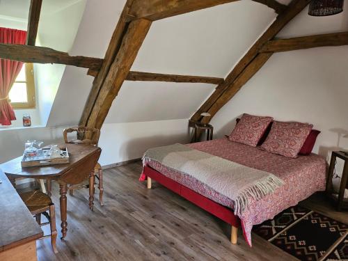 a bedroom with a bed and a table at La Tilia in Saint-Riquier