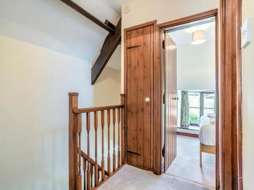 a hallway with a wooden door leading to a bedroom at Black Bull Cottage in Ugthorpe