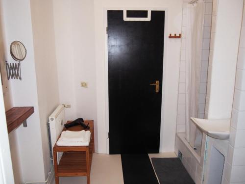 a black door in a bathroom with a sink at Box61 Art Concept Flat in Berlin