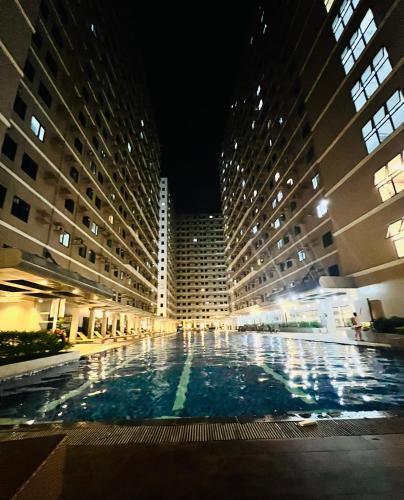 a large building with a large swimming pool at night at Tower1 Smdc green2 Dasmarinas in Dasmariñas