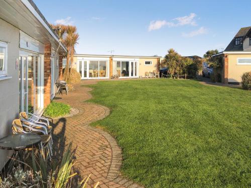 a patio with chairs and a grass yard at No 1 Hickling Chalet - Uk51726 in Scratby