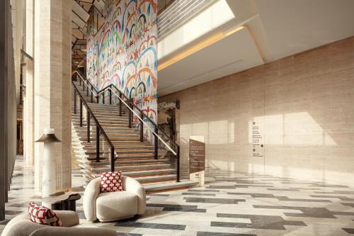 a lobby with a staircase and a mural on the wall at W Riyadh - KAFD in Riyadh