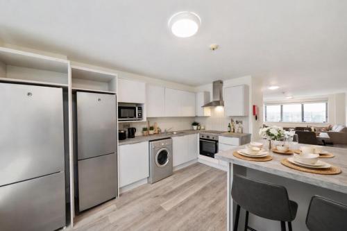 a kitchen with stainless steel appliances and a table at Canvas Mayor Square in Dublin