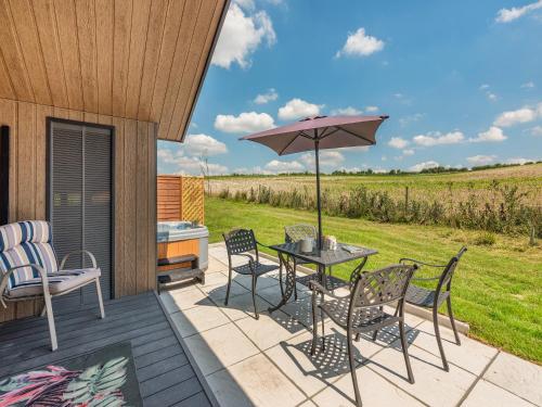 a patio with a table and chairs and an umbrella at Cranbourne Chase Stargazer - Ukc6914 in Pentridge