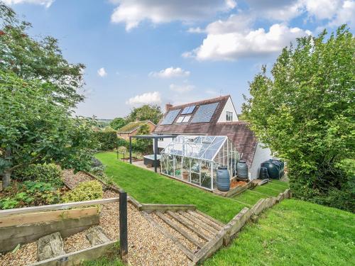 an image of a house with a greenhouse in the yard at Blackthorn House in Blandford Forum