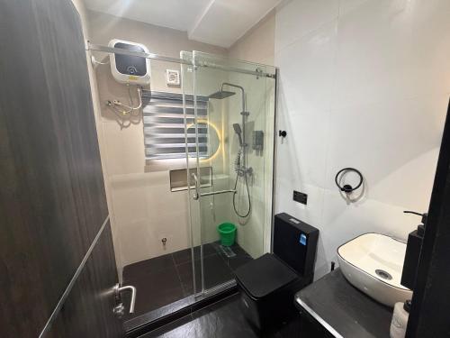a bathroom with a shower and a toilet and a sink at House 9 Signature in Port Harcourt