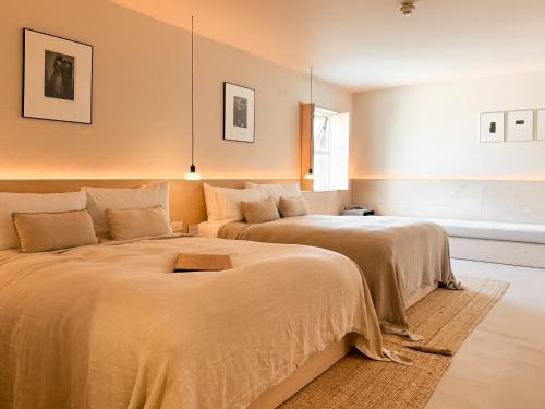 two beds in a large room with two beds sidx sidx sidx at Fiddle + Bow Hotel in Doolin
