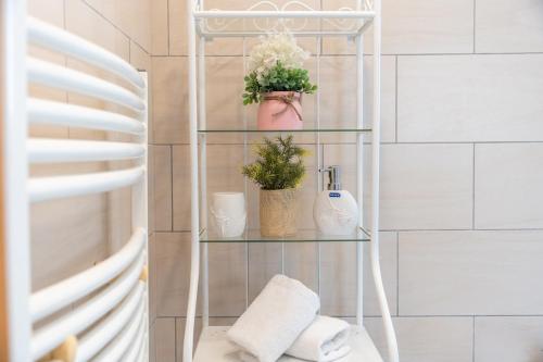 a glass shelf with plants and towels in a bathroom at Dream Olea Villa - Ayia Napa in Ayia Napa