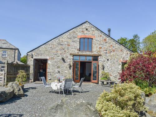 a stone house with a table and chairs in front of it at The Barton in Launceston