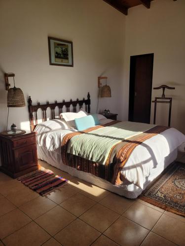 a bedroom with a large bed with a wooden headboard at La Perdida Casa de Campo in San Antonio de Areco