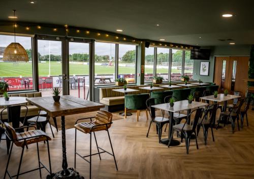 a restaurant with tables and chairs and a baseball field at Nine Yards Bell Tents - Lytham in Lytham St Annes