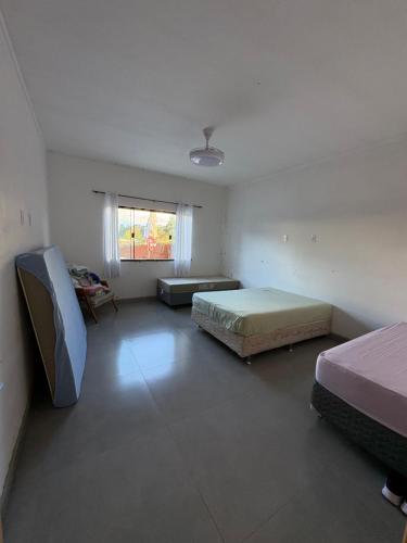 a large room with two beds and a window at Recanto Gil Viana in Pouso Alegre