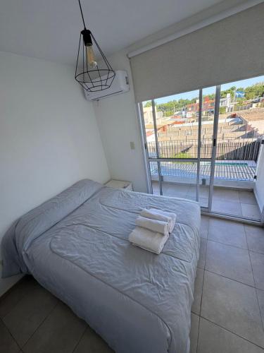 a bedroom with a bed with two towels on it at Beautiful fully-equipped duplex in Ezeiza