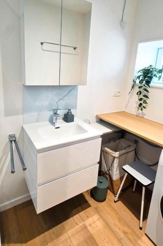a white kitchen with a sink and a desk at Cottage des Cerisiers in Lens