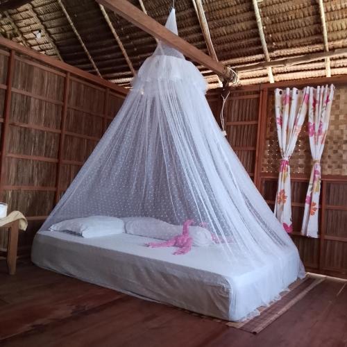a bed in a room with a net at Batanta Explorers in Pulau Saonek-kecil