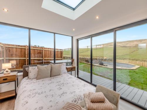 a bedroom with a bed and large glass windows at The Bunker - Uk40225 in Bardon Mill