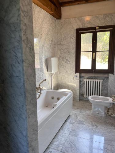 a white bathroom with a tub and a sink at Villa Riviera in Mira