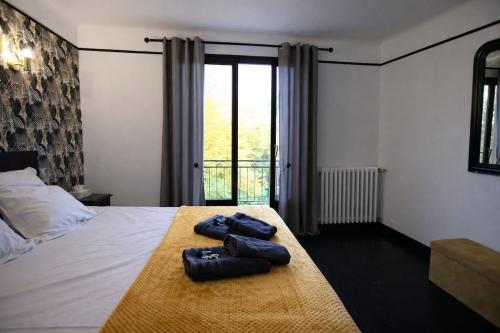 a bedroom with a bed with two slippers on it at Maison 10 personnes 4 chambre 2 sdb in Liourdres