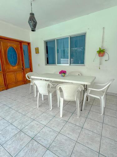 a white table and chairs in a room with windows at Casa de las Iguanas Tecolutla in Tecolutla