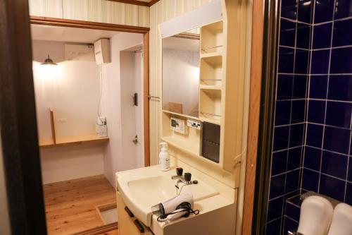 a bathroom with a sink and a mirror at Aburatsu Inn Kadocco in Nichinan