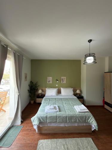a bedroom with a large bed and a large window at Down Town Apartments in Kavála