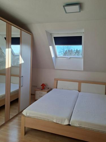 a bedroom with a large bed and a window at Haus Seeblick in Jettingen-Scheppach