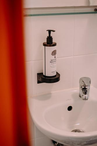 a bathroom sink with a soap dispenser on it at Hotel Restauracja Jaś Wędrowniczek in Rymanów