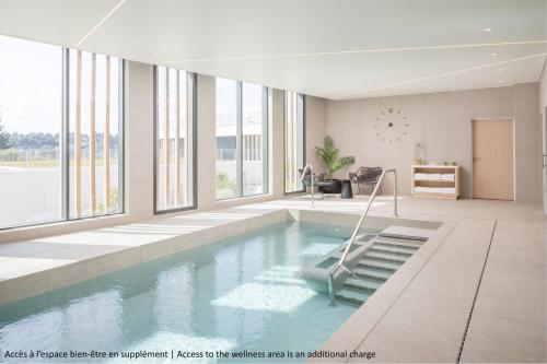 a large swimming pool in a room with windows at Hyatt Place Rouen in Rouen