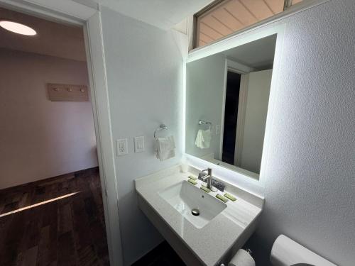a bathroom with a white sink and a mirror at Bravo Inn Greensboro in Greensboro