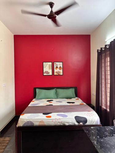 a red bedroom with a bed with a ceiling fan at The Prime Residences of Samuels Comfort Homes in Bangalore