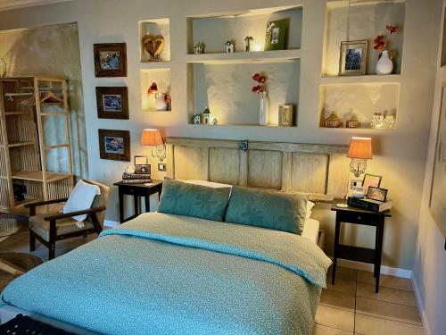 a bedroom with a bed with blue sheets and mirrors at Villa Basilicata in Pedale